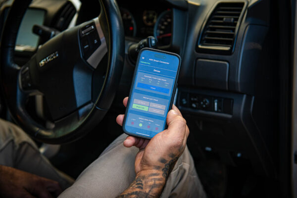 Hand holding phone displaying the ARK Smart Connector app.