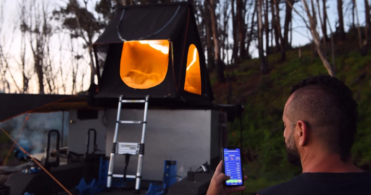 Man looking at his phone in an outdoor camp area