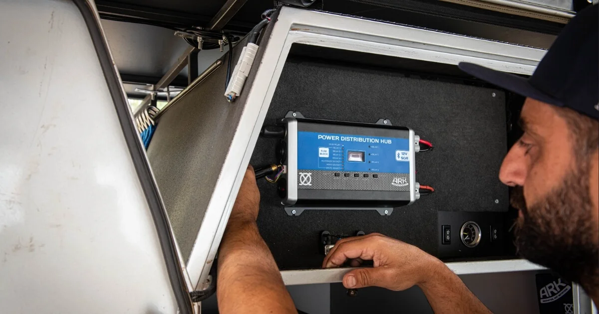 A man installing the Ark Power Distribution Hub