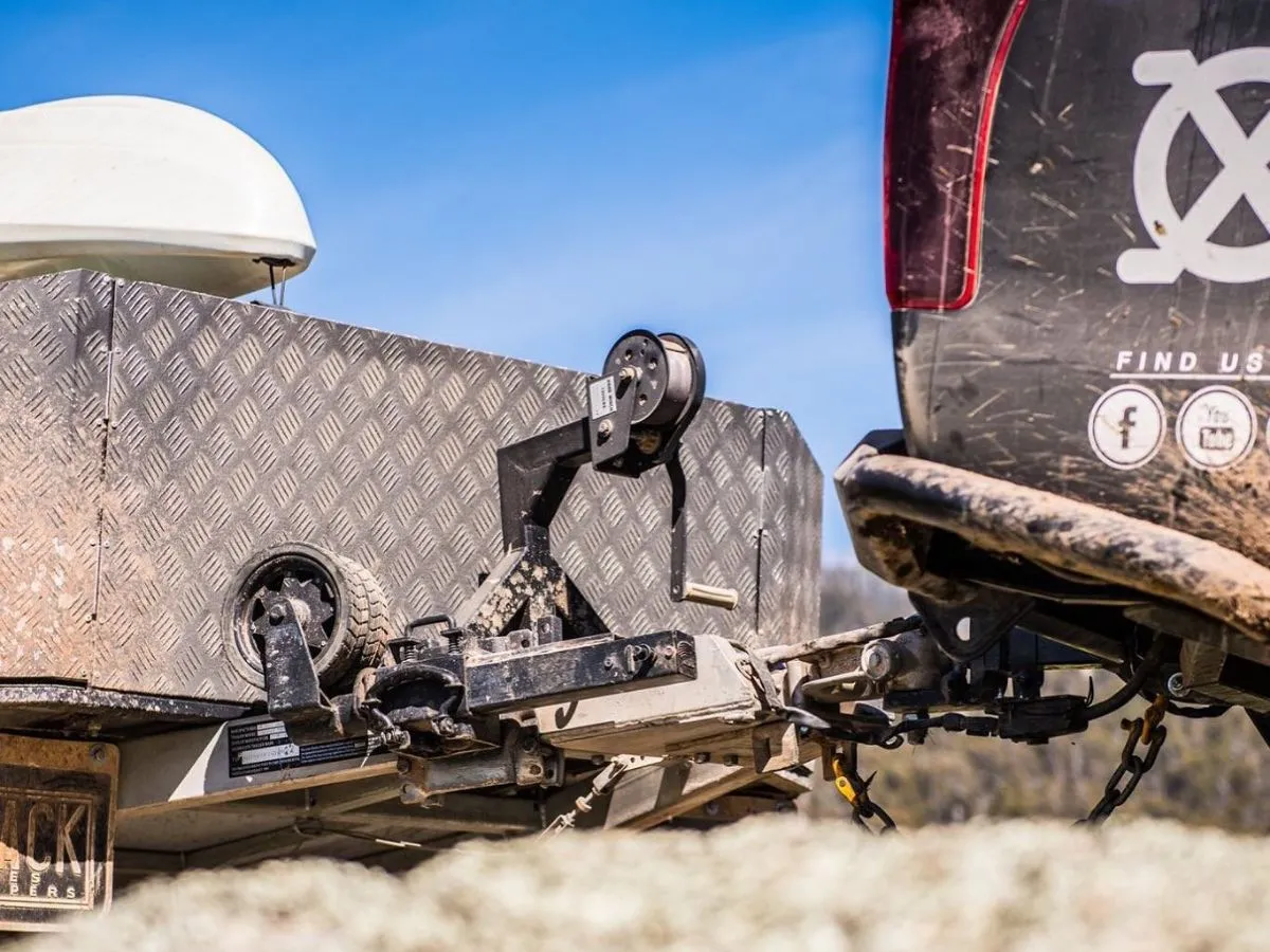 Trailer coupling and drawbar connected to a 4WD tow bar, with safety chains and jockey wheel.